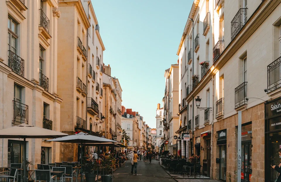 Façades en pierre claire et rue piétonne du centre de Nantes.